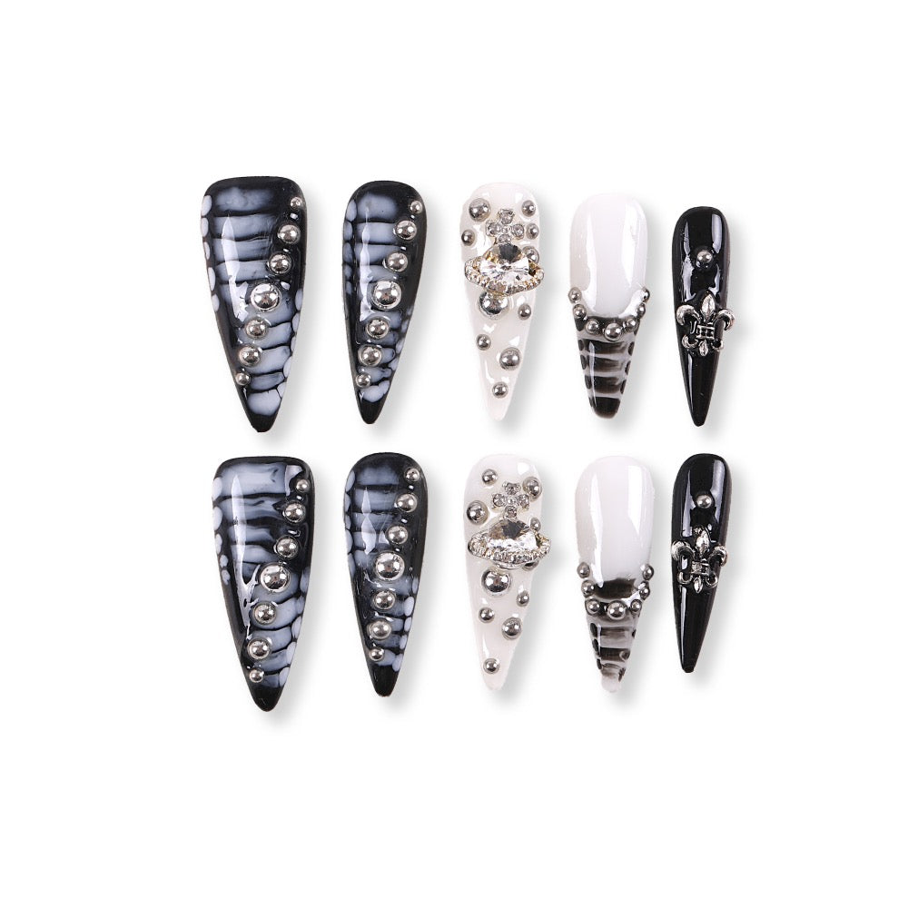 Uñas postizas de estilete con diseño de mármol blanco y negro de 365Nails con dijes de pedrería.
