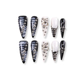 Uñas postizas de estilete con diseño de mármol blanco y negro de 365Nails con dijes de pedrería.