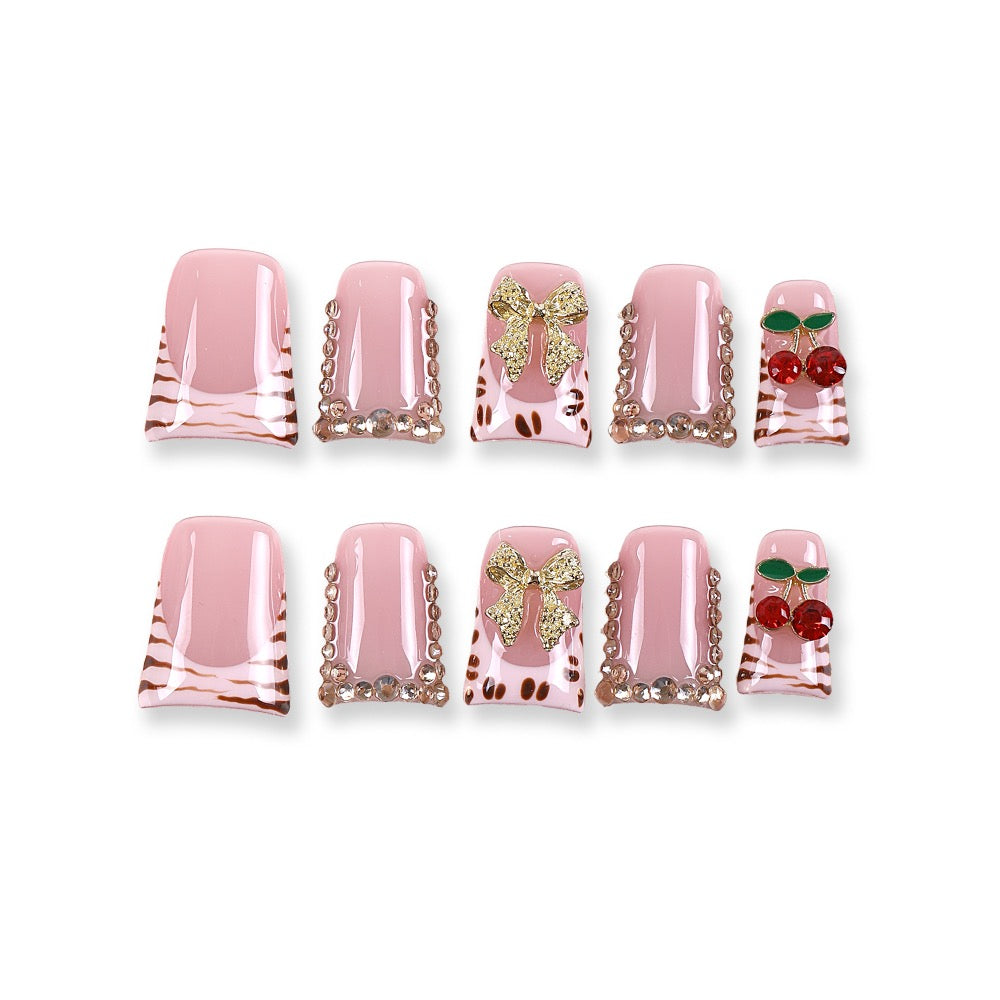 Uñas postizas 365nails color rosa bebé con estampado de leopardo, cerezas y lazo.