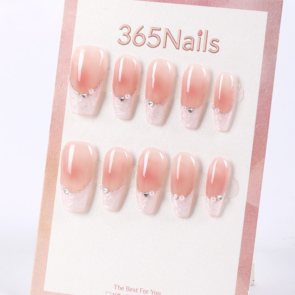 Uñas postizas largas de ataúd 365Nails con efecto degradado rosa, perlas y cutículas brillantes.