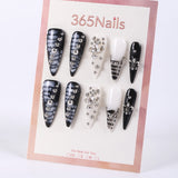 Uñas postizas de estilete con diseño de mármol blanco y negro de 365Nails con dijes de pedrería.