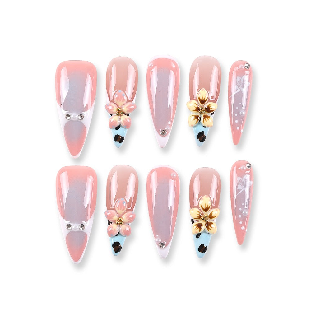 Uñas postizas 365Nails color nude-coral gris degradado con flores doradas 3D y detalles de perlas francesas.