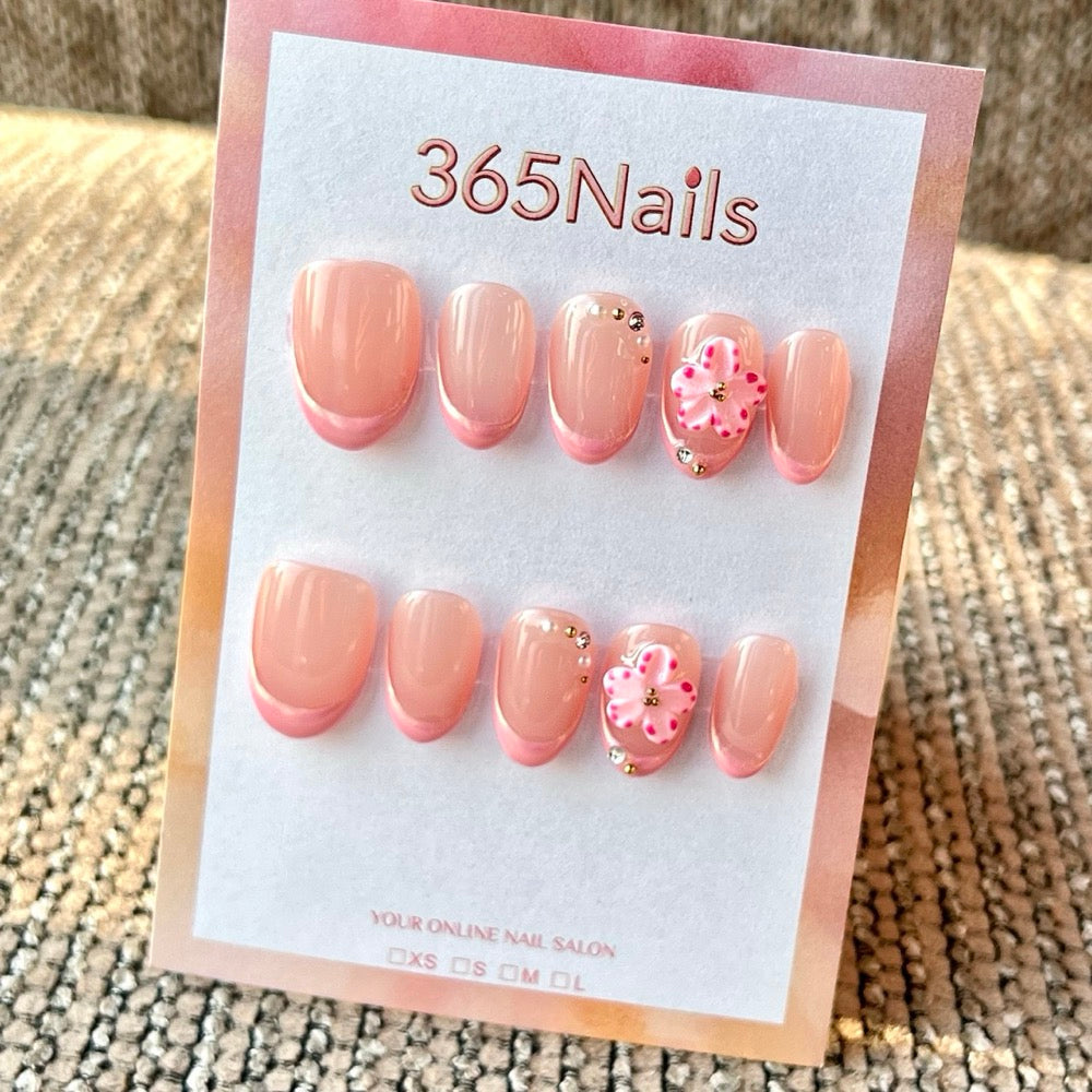 Handmade cherry blossom French press-on nails with 3D flower accents in short oval shape