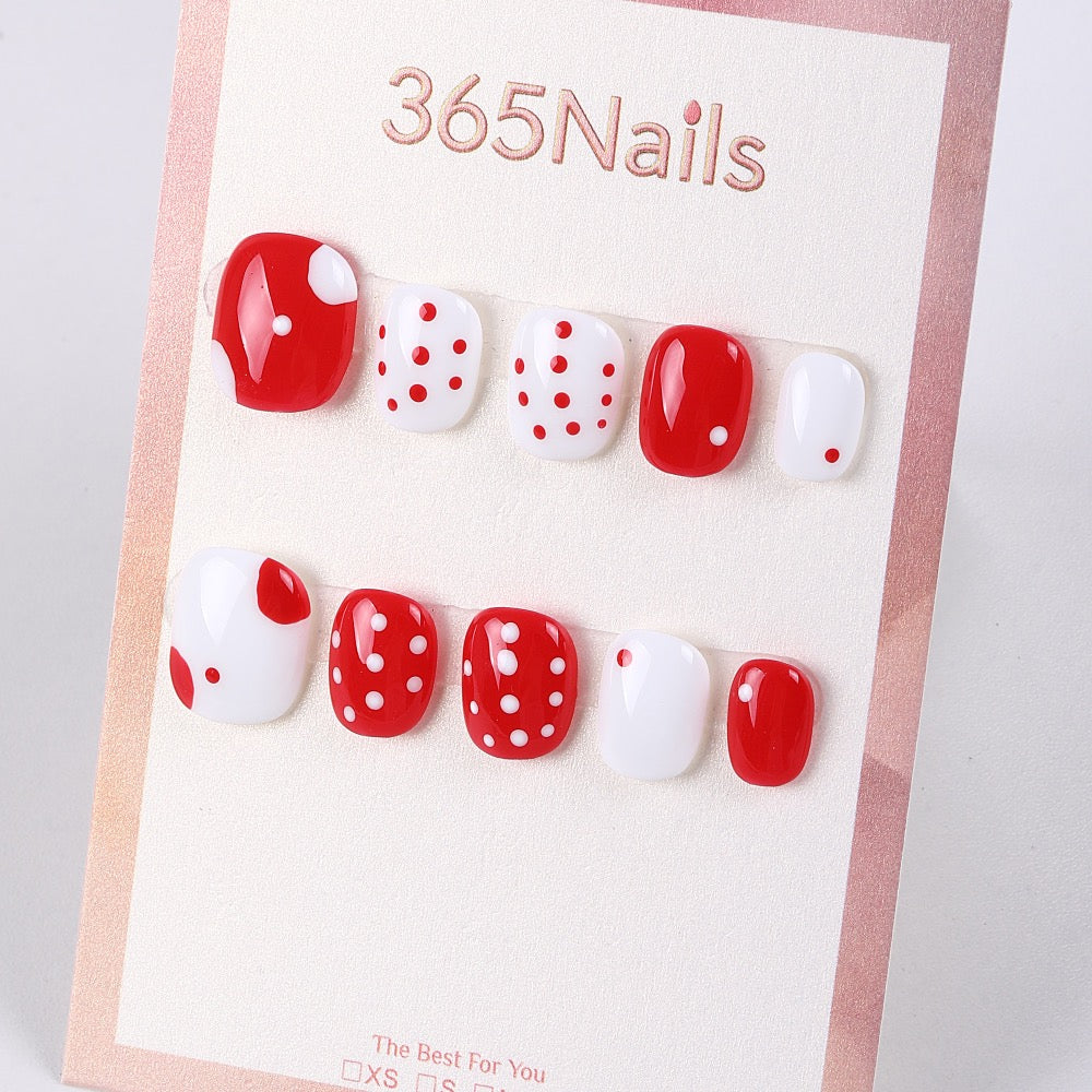 Bright red and white polka dot press-on nails with glossy finish, perfect for wholesale supplier evaluation.