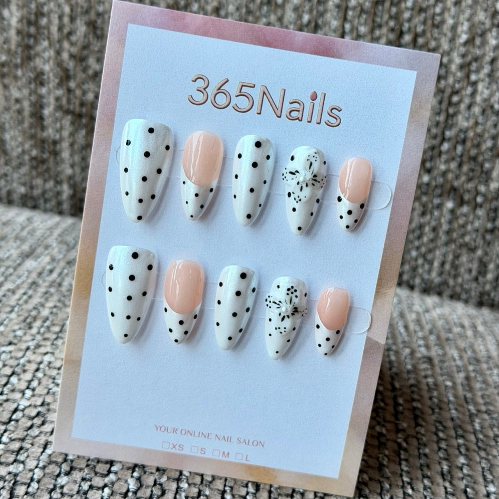 Nude black polka dot splatter handmade press-on nails displayed on a white background, representing the quality products salons and retailers can source wholesale.
