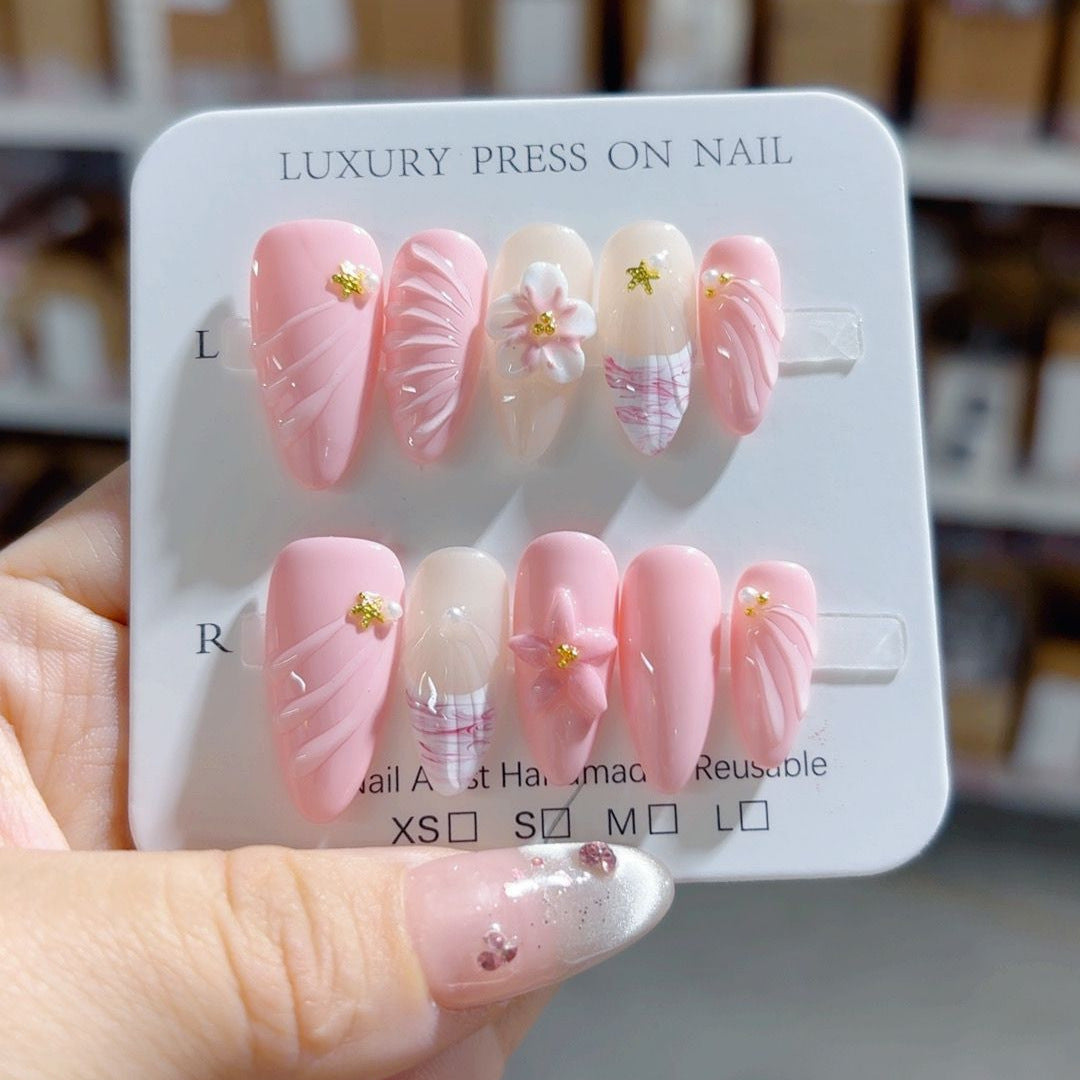 Handmade Sakura Whisper almond press-on nails with carved 3D cherry blossom design and rhinestones, suitable for private-label dropshipping product photography.