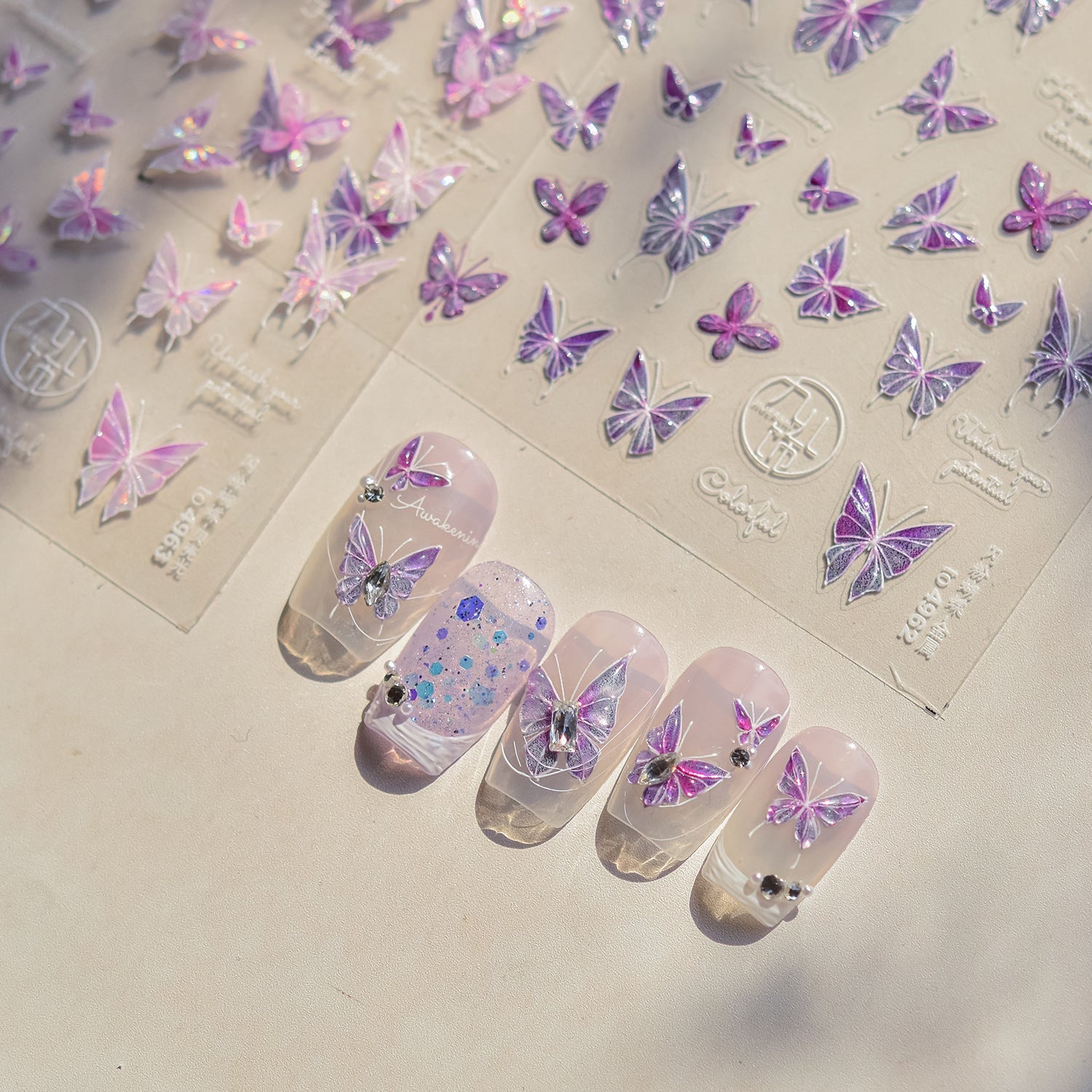 Wholesale assortment of press-on nail sets arranged as product cards with inventory notes and packaging samples on a clean white table.