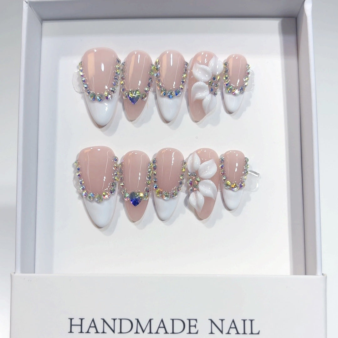 White rhinestone floral almond press-on nails with glossy finish, ready for wholesale quality inspection.