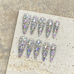 Luxury crystal stiletto press-on nails with rhinestones and glitter on a neutral background, showing finished press-on nail quality for wholesale buyers