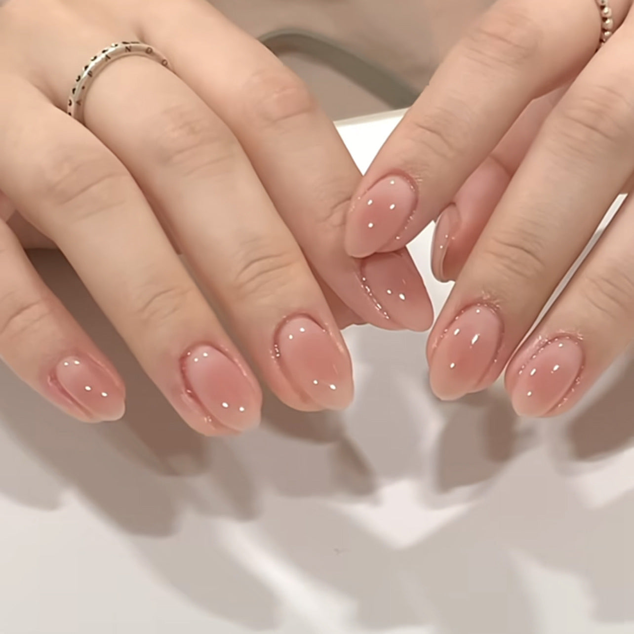Peach ombre oval press-on nails with gradient nude finish, displayed for retail wholesale assortment planning.