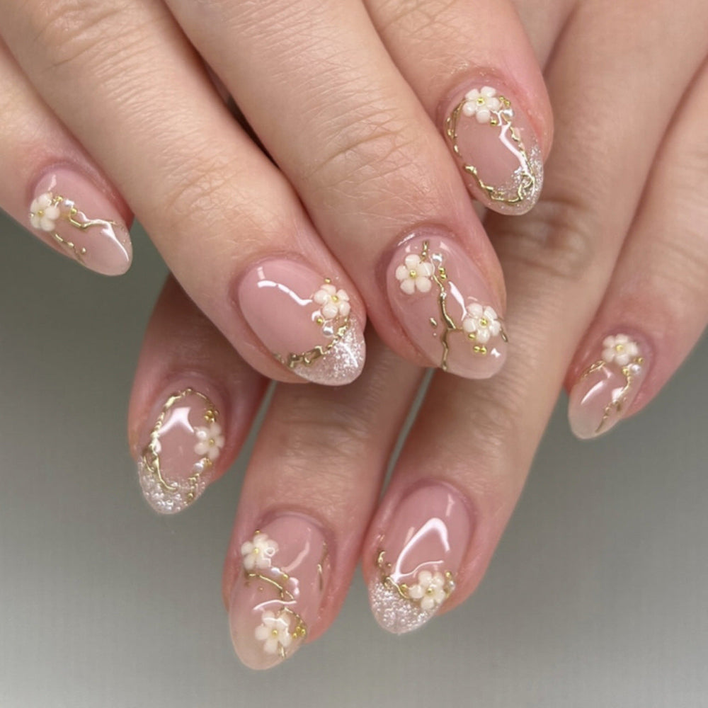 Soft pink almond press-on nails with floral design and gold details, representing a private-label packaging insert and brand launch ready product.