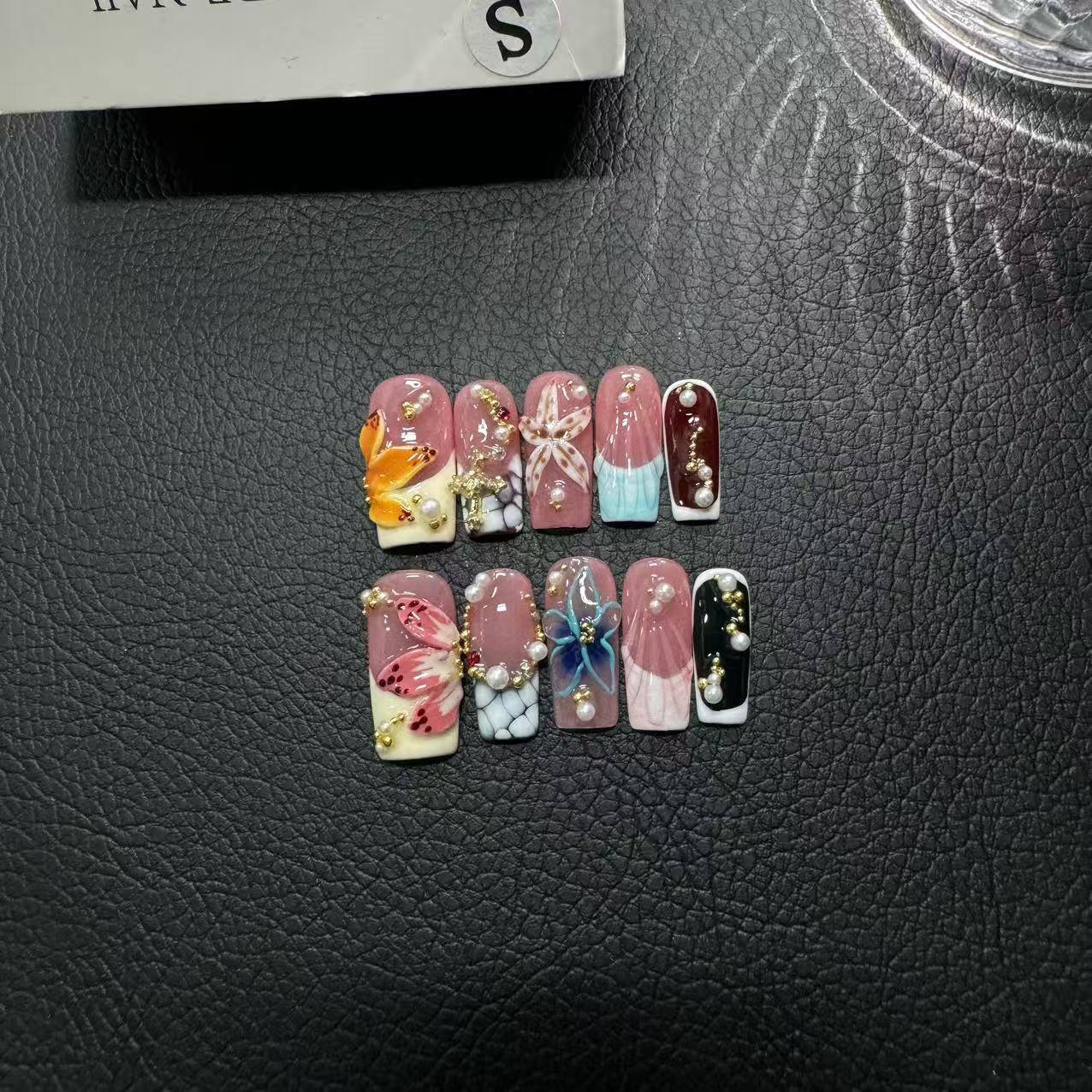 Custom ODM press-on nail sample with 3D floral coffin design in blue pink and white, showing detailed handmade nail art for beauty brand quality review.
