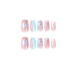 Pink press-on nails with blue accents, flowers and heart details