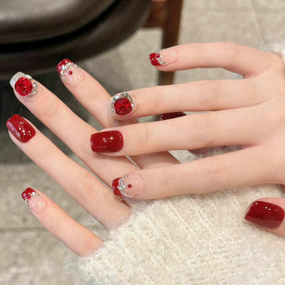 Wholesale press-on nail set featuring crimson floral rhinestone design on short square nails, ideal for salon retail restocking.