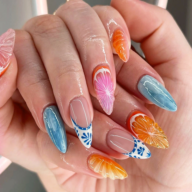 3D press-on nails featuring ocean orange fruit design on a model's hand