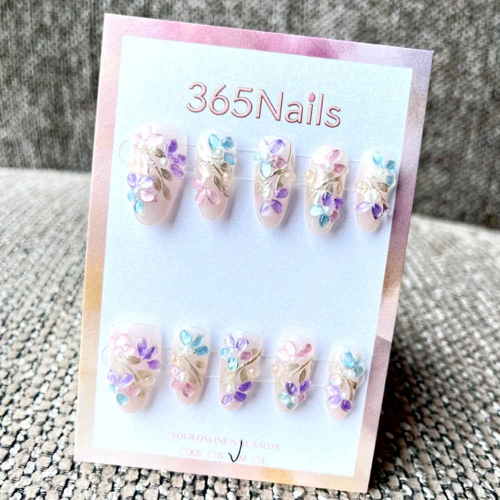Handmade 3D floral press-on nails in pastel colors displayed in minimal white packaging, representing private-label brand presentation