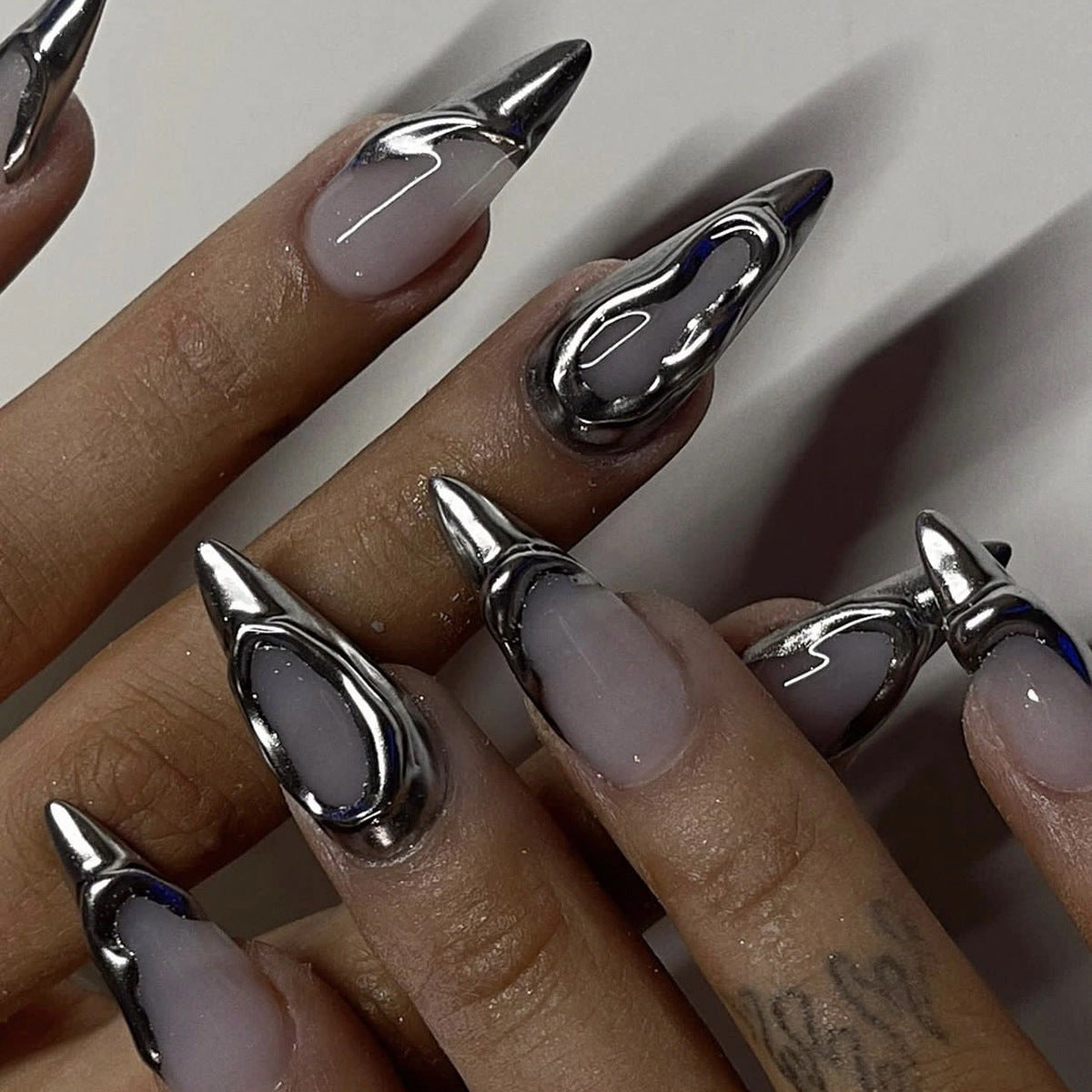 Futuristic silver liquid metal 3D press-on nails with chrome effect, ideal for private label dropshipping brands.
