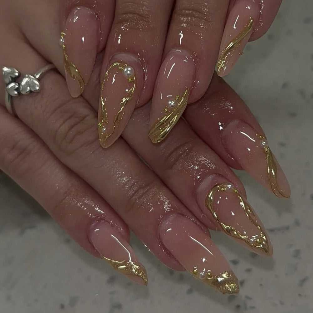 Elegant nude gold swirl press-on nails with 3D pearls, a luxurious bridal design perfect for wedding season wholesale and salon retail.