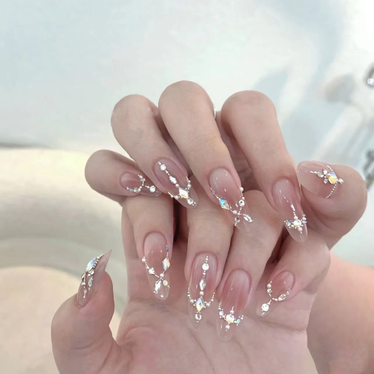 Glamorous blush aura rhinestone drip press-on nails exemplifying high-quality craftsmanship and intricate 3D detailing.