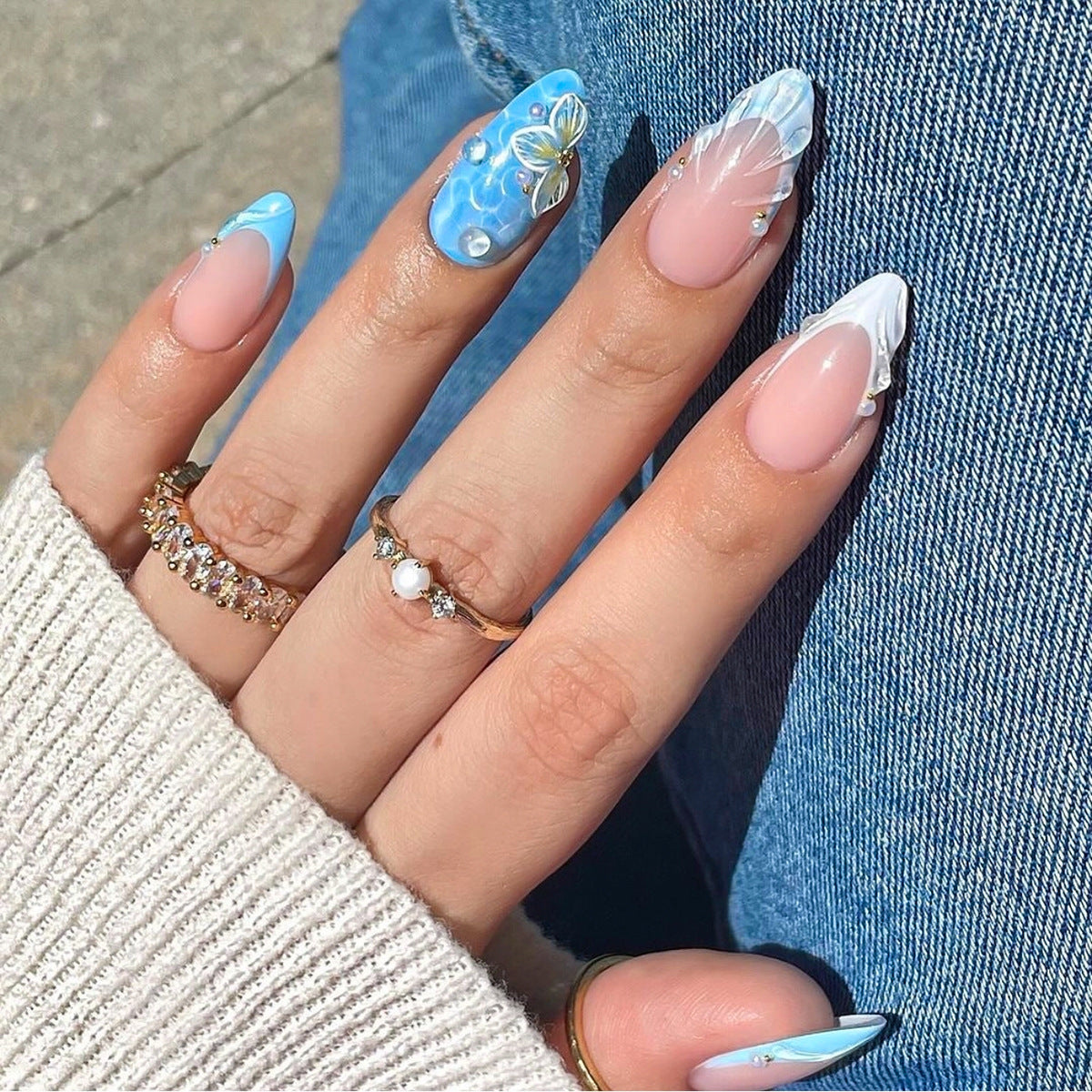 Wholesale press-on nail assortment featuring blue and white floral French tips with 3D shell and waterdrop accents