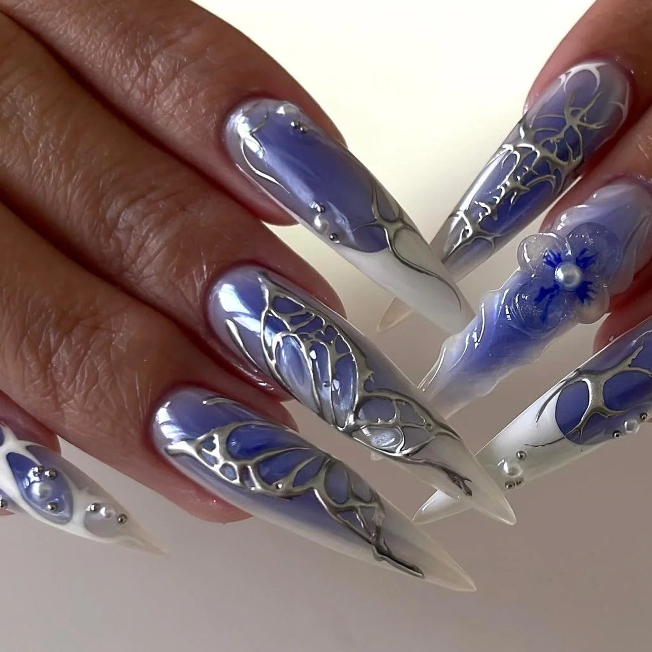 Custom ODM press-on nails with Y2K blue jelly french stiletto design featuring silver butterflies and 3D flowers, ideal for trend-driven seasonal collections.