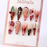 Uñas postizas 365nails con base nude, degradado rojo con efecto carey, cerezas y diseño floral, estilo stiletto/almendrado.