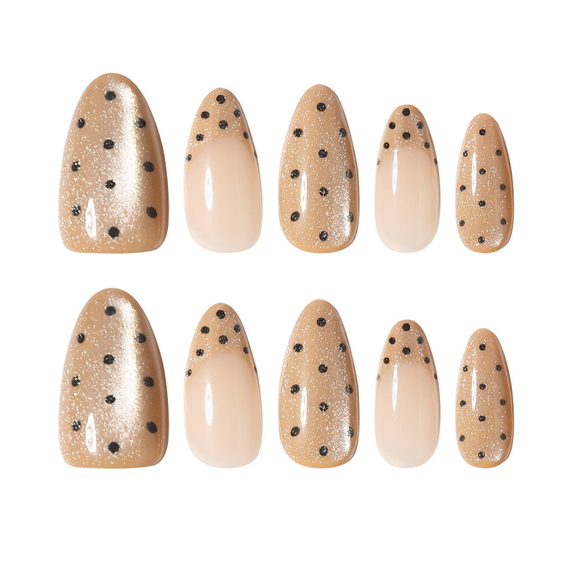 Ten almond press-on nails with black polka dots and glitter displayed in two rows