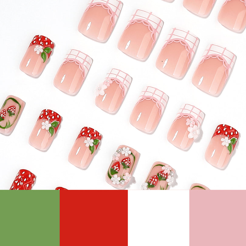 Scattered pink square press-on nails with strawberry charms on white background