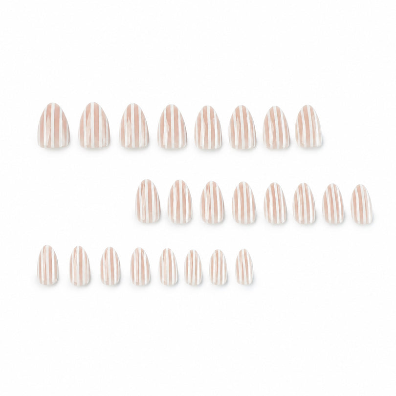 Set of nude and white striped press-on nail tips laid out in rows