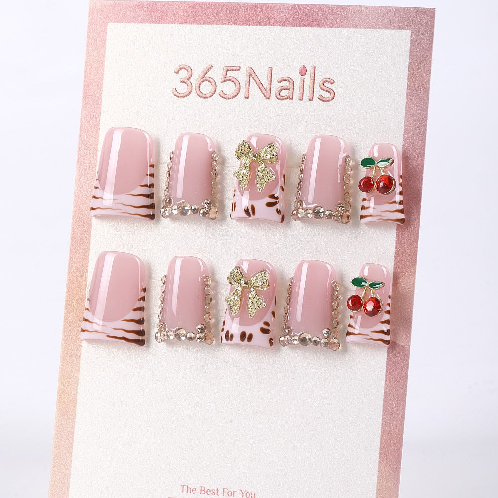 Uñas postizas 365nails color rosa bebé con estampado de leopardo, cerezas y lazo.