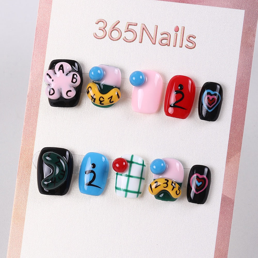 Uñas cortas pintadas a mano con diseños de garabatos de la escuela 365Nails