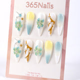 Uñas postizas 365Nails color blanco lechoso estilo francés con degradado azul menta y limón, flores 3D y cuentas plateadas.