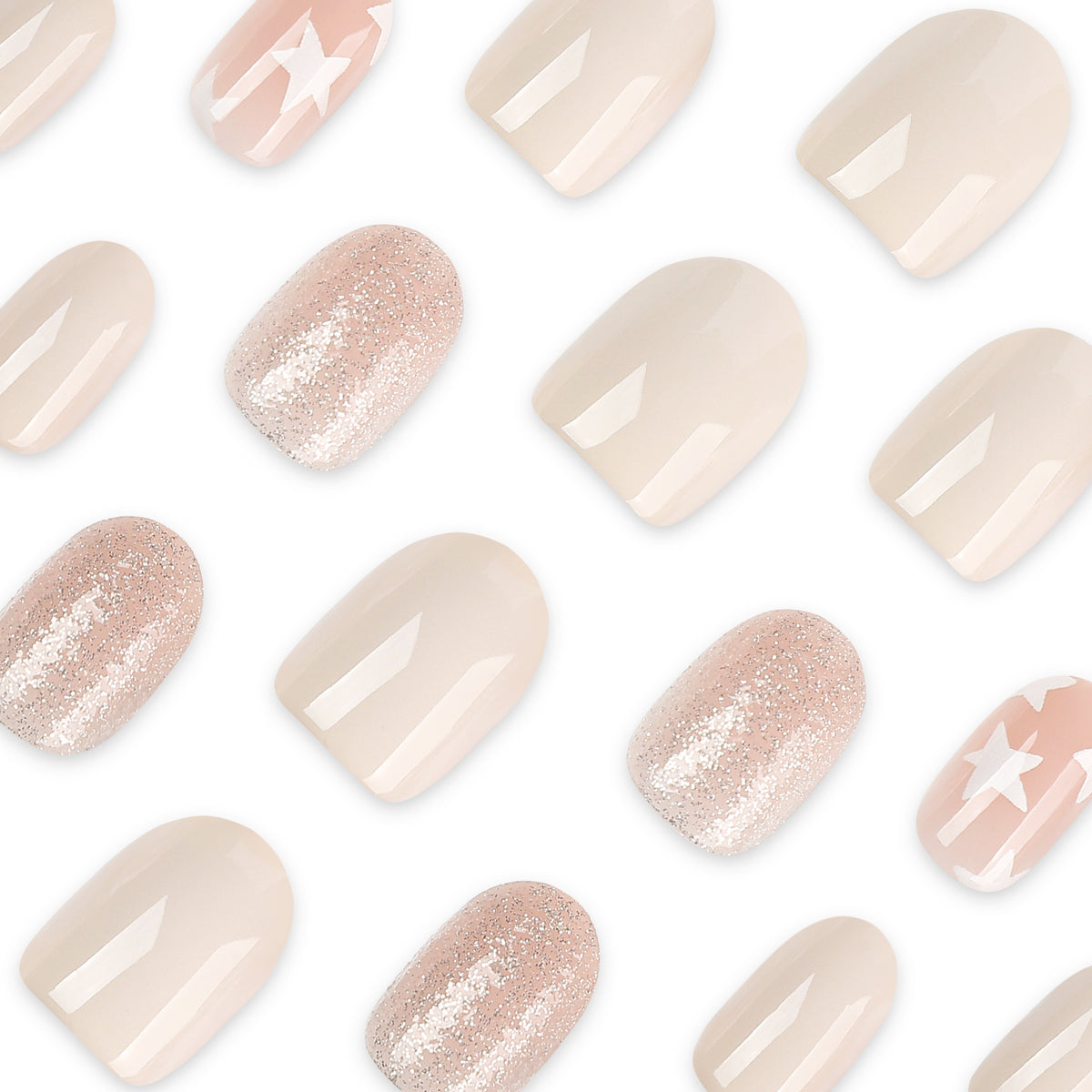 Close-up of scattered press-on nails in nude, glitter rose, and star-patterned pink finishes