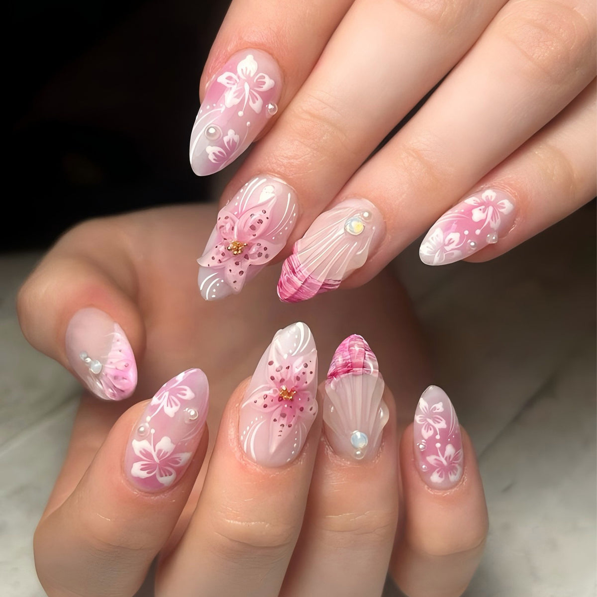 Hand wearing pink floral almond press-on nails with 3D flower accents