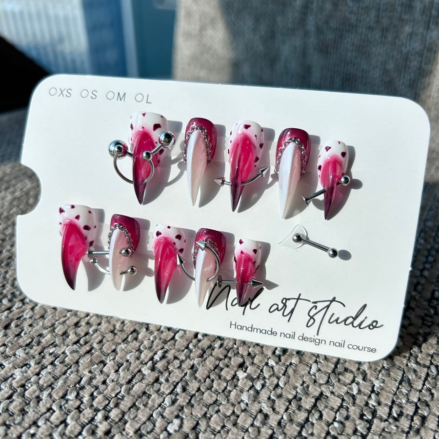 Ongles press-on chaîne Cœur Sombre — bordeaux, forme stiletto avec cœurs et piercings