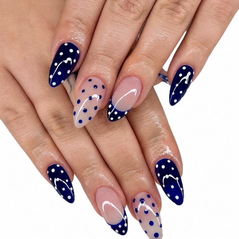 Close-up of hand wearing blue and nude polka dot almond press-on nails