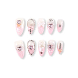 Uñas postizas 365Nails color blanco lechoso con degradado rosa bebé, corazones con ribete de perlas, pedrería y lazos 3D.