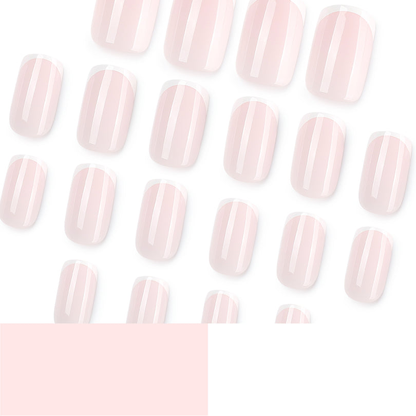 Many pale pink French tip press-on nails scattered on a white background