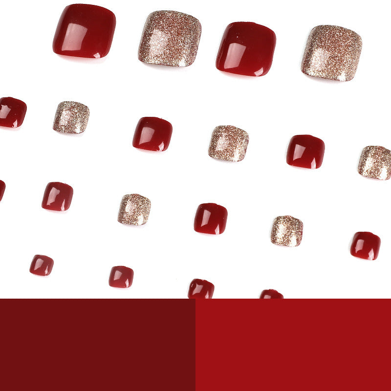 Scattered red and glitter press-on toenails on a white background.