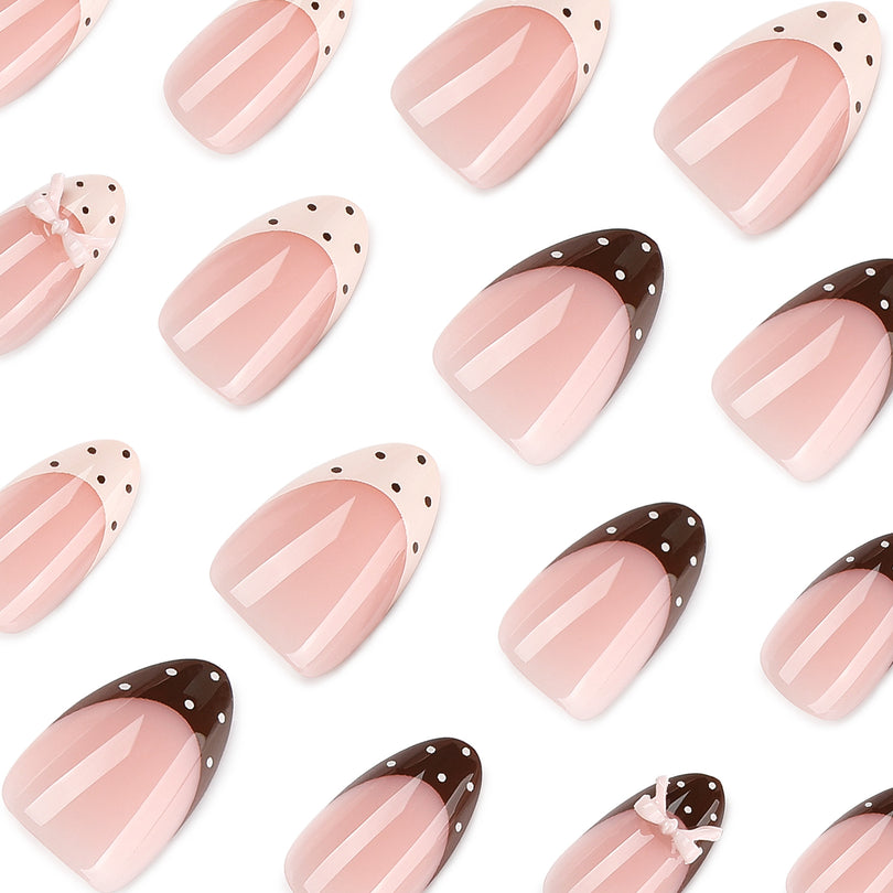 Top view of many almond nails with polka-dot French tips and small bow decorations