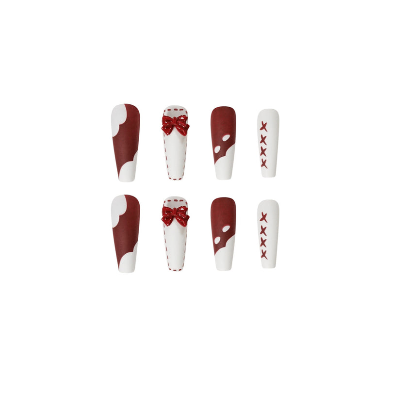 Close-up of eight nails showing four designs with glossy red bows and painted X accents