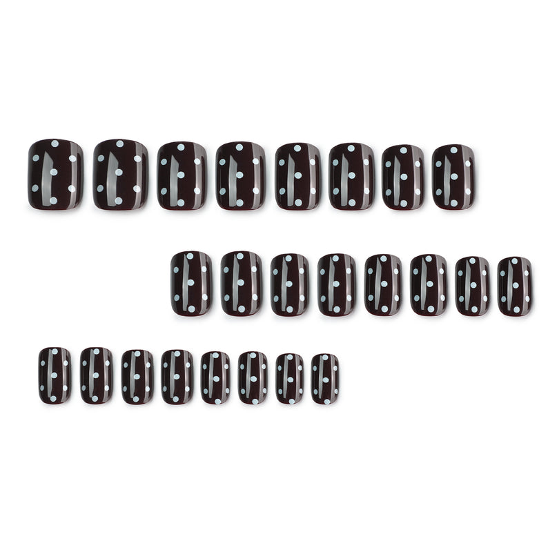 Set of 24 black square press-on nails with white dots laid in rows