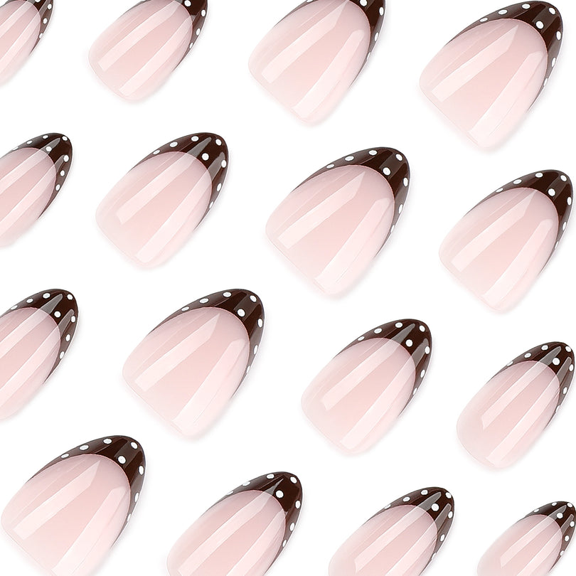 Close-up of pink almond nails with dark brown polka dot French tips on white background