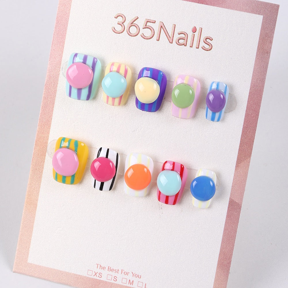 Uñas postizas con diseño de rayas y botones de caramelo de 365Nails.