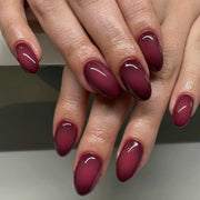 Hand wearing glossy deep red almond press-on nails