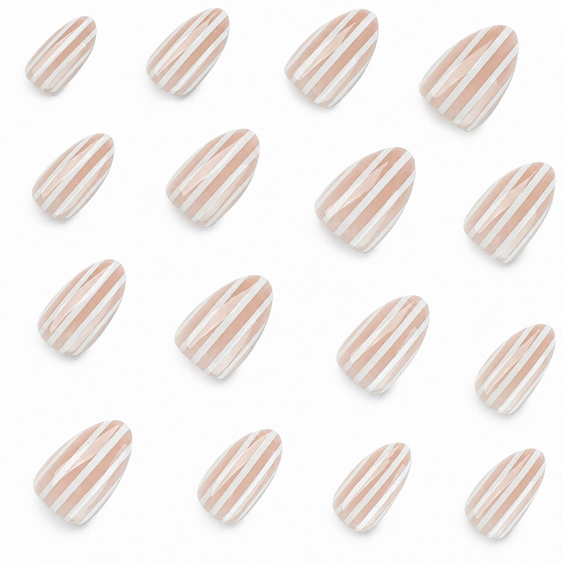 Multiple nude striped false nails scattered on white background