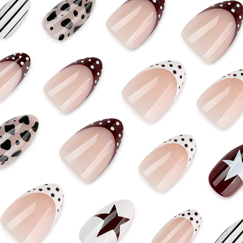 Close-up of glossy short almond press-on nails with nude base and black, white and burgundy patterns.