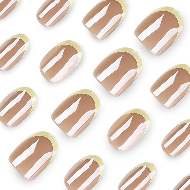 Close-up of glossy nude press-on nails with yellow French tips