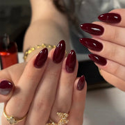 Hand wearing glossy deep wine red almond press-on nails