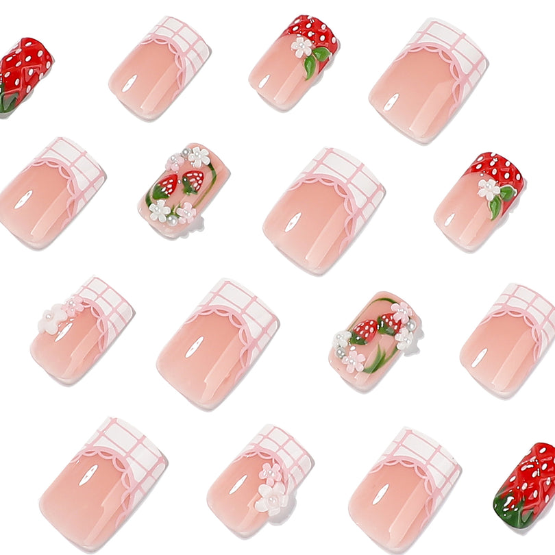 Close-up grid of pink square nails with strawberry, flower and lace accents